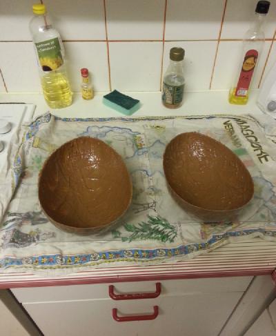 Photo of two giant egg moulds coated in a thin layer of molten chocolate