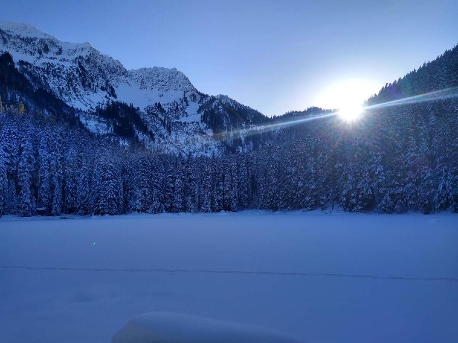 A farewall glare from the sun over the frozen lake.