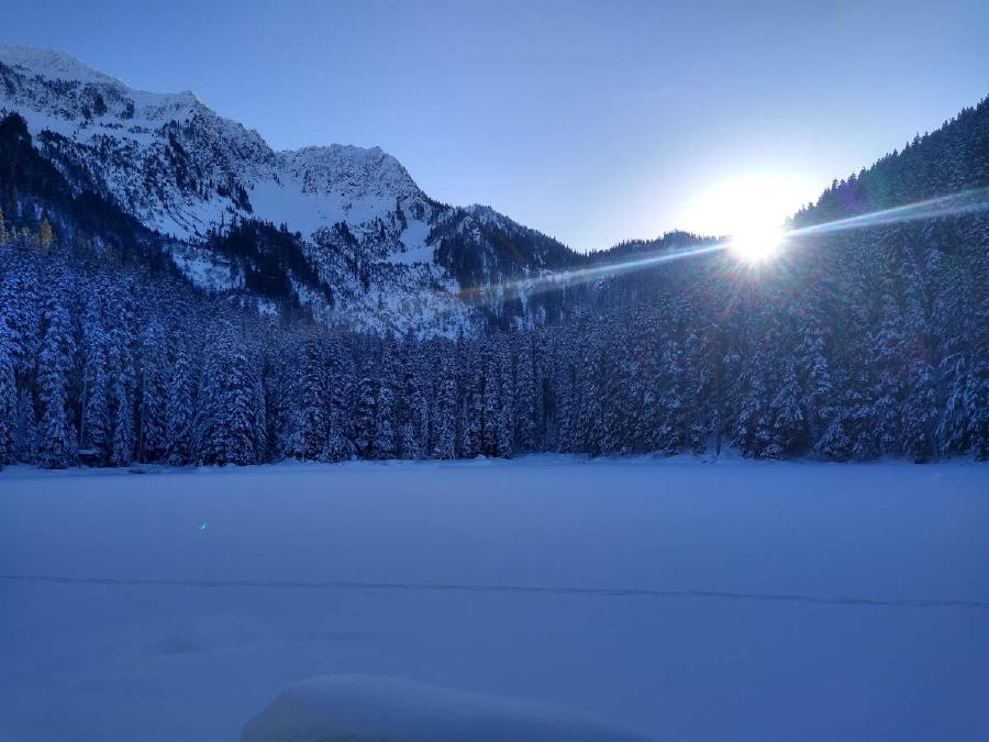 A farewall glare from the sun over the frozen lake.