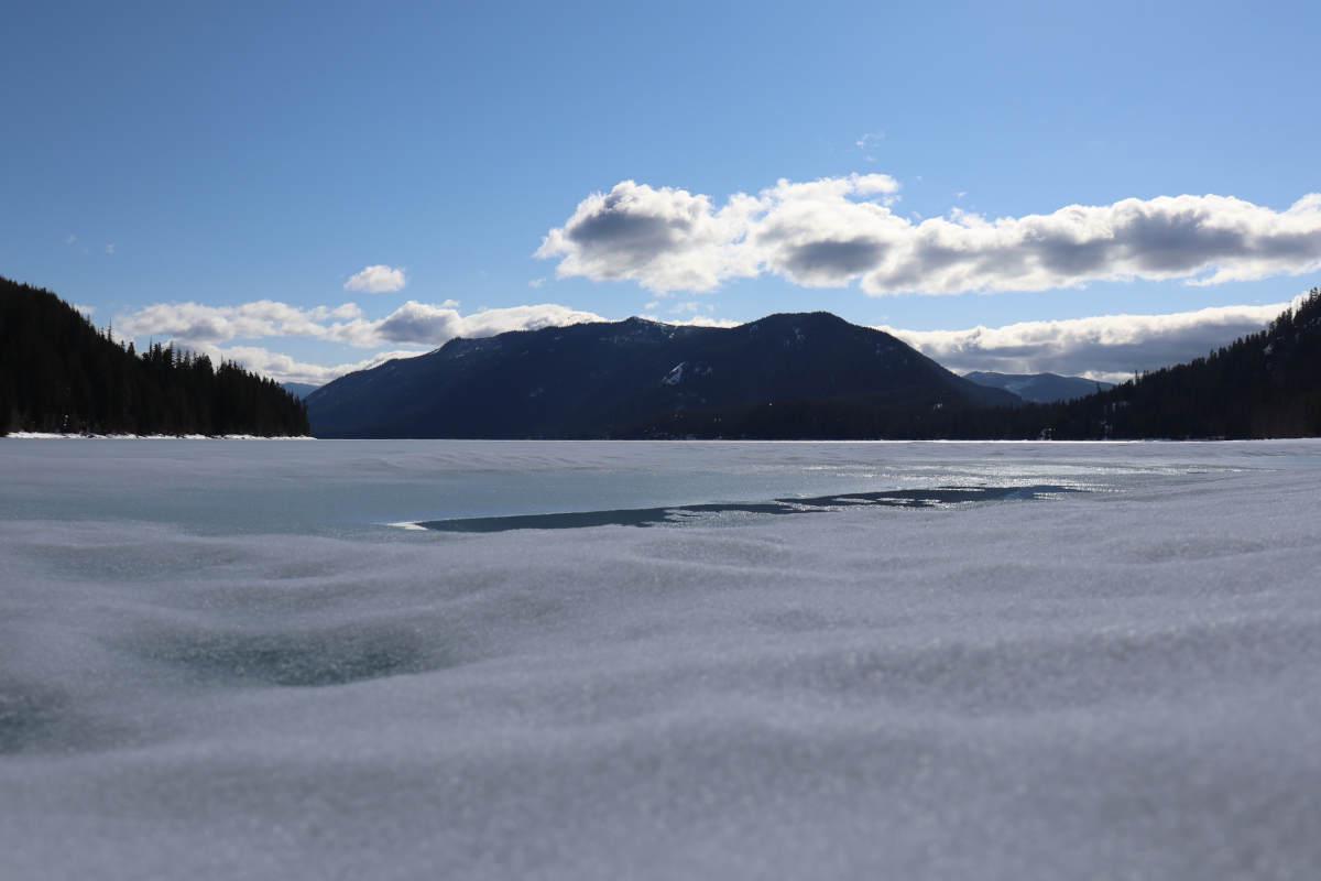 A close up of the frozen lake with distant mountains.