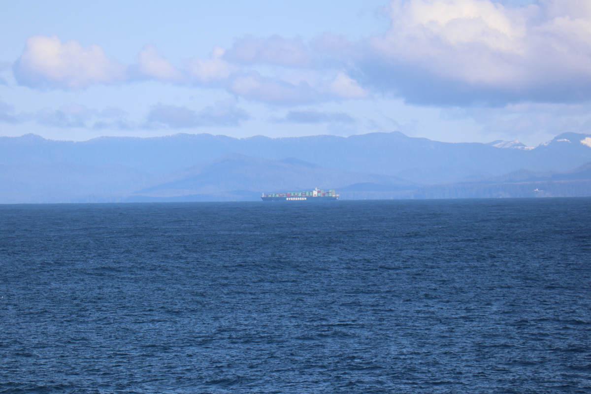Sea, mountains, and a large container ship.