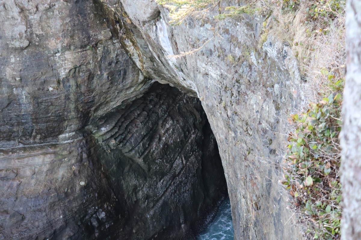 Looking down into the opening of a sea cave.