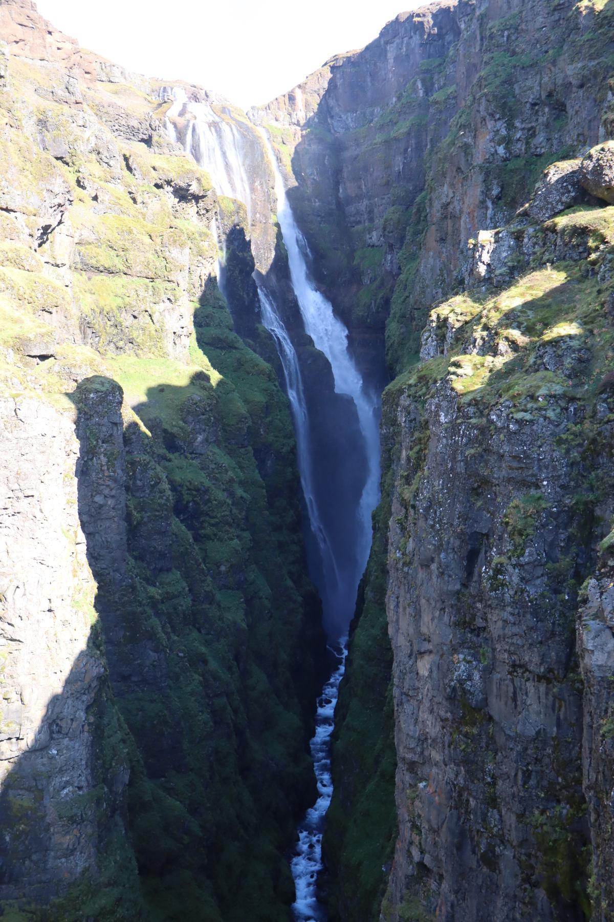 Photo looking straight through deep canyon, with a view of white water cascading down the 198m drop.