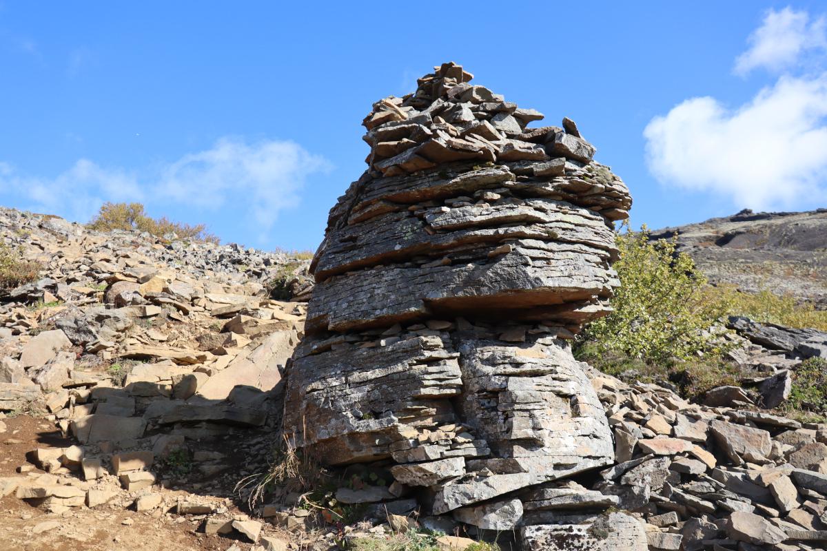 Photo of what looks like a cairn, though appears to be mostly natural with a some human-placed rocks on top.
