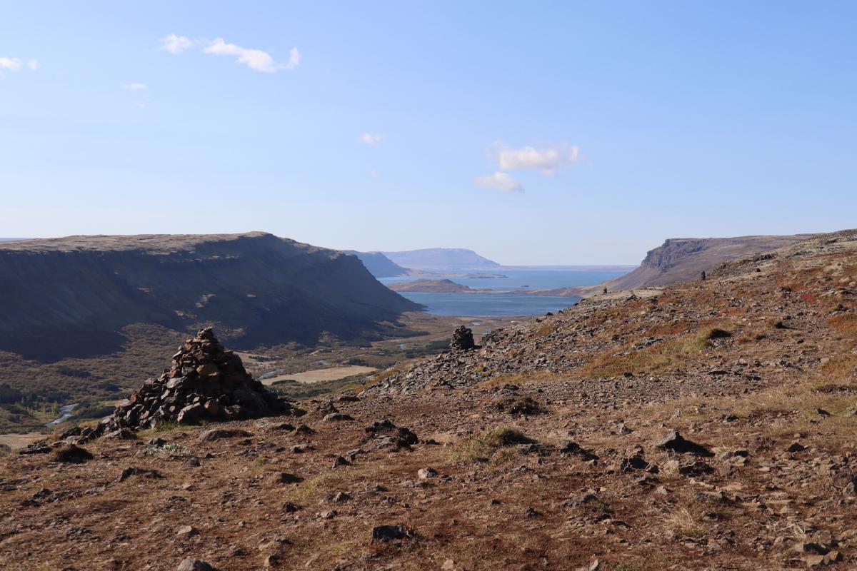 Photo from the top of the ridge out to sea, with a row of widely spaced cairns disappearing into the distance.