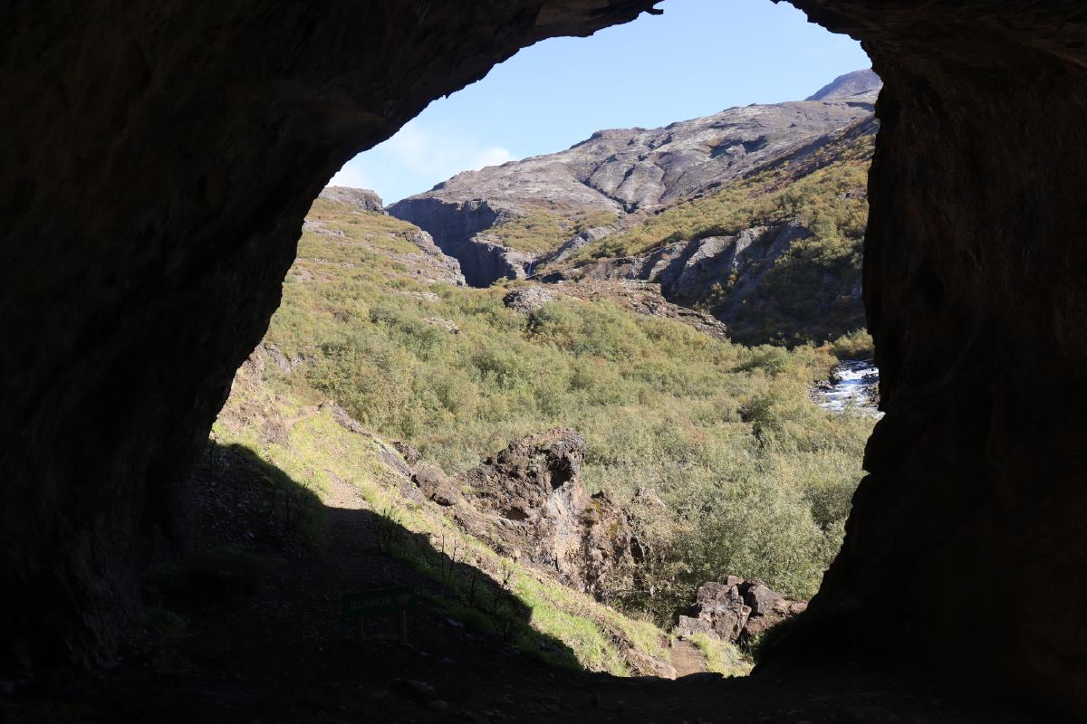 Photo of canyon in distance, with the nearby cave wall framing the shot.