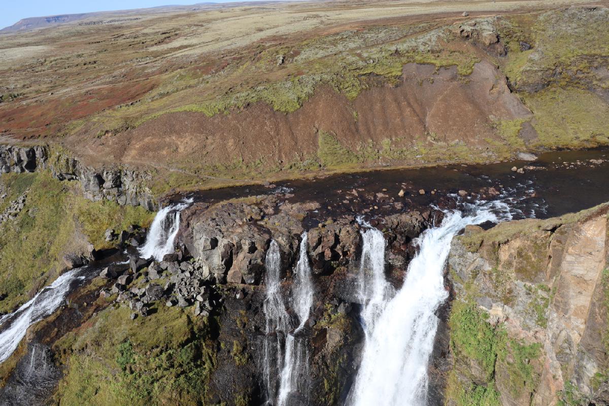 Photo looking down from above the top of the waterfall, showing the river suddenly plummet into the canyon.