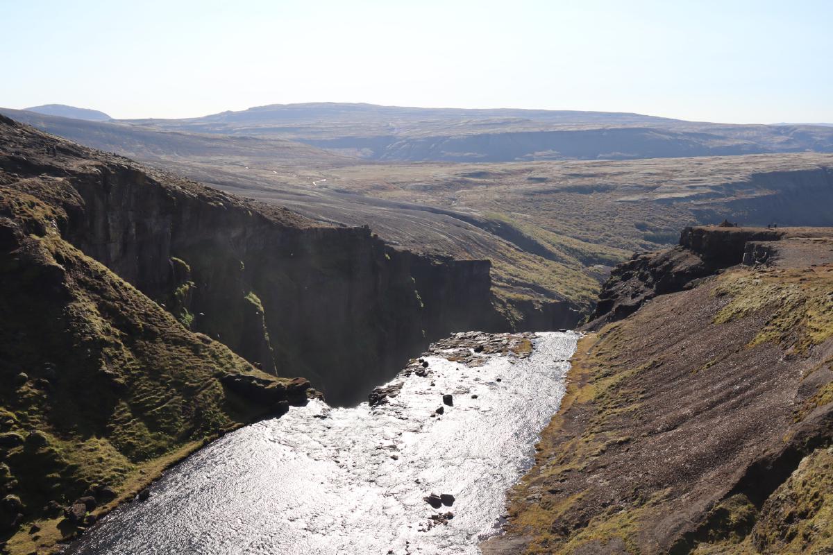Photo from above the waterfall, but the waterfall is not visible, so the river appears to vanish off the edge of a cliff.