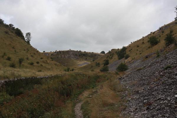 Looking through a green valley with scree on the right.