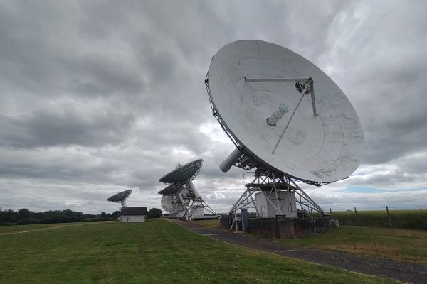 Several big parabolic receivers, the nearby ones static, the distant ones mounted on a track.