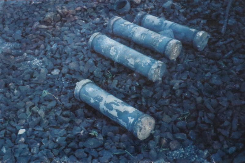 Four grey tubes on large gravel.