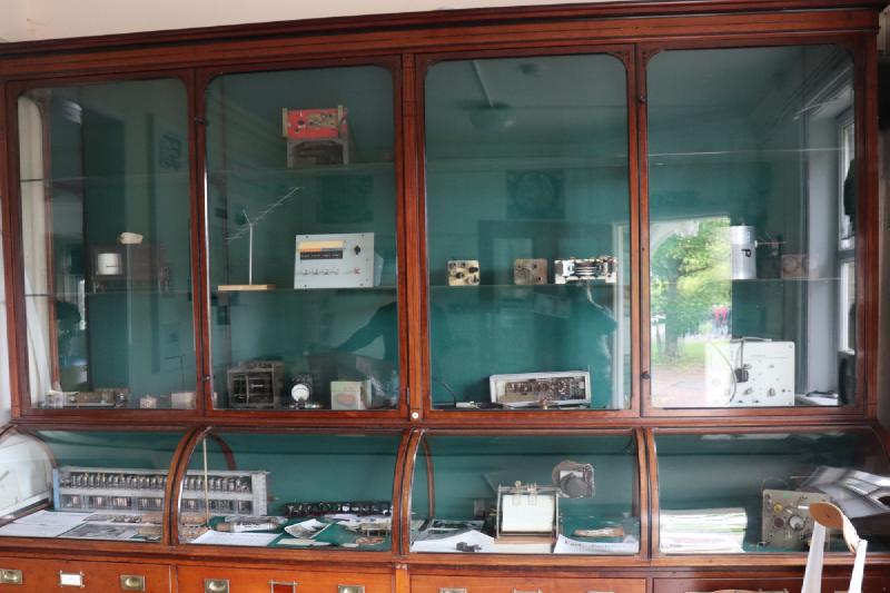 A large, old cabinet, filled with various old radio equipment.