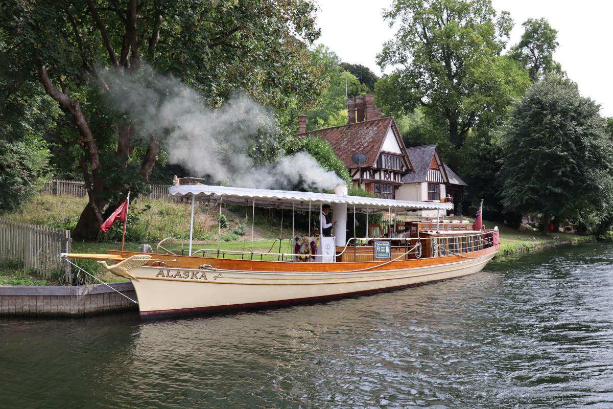 An old fashioned steamboat, with steam pouring out the chimney.