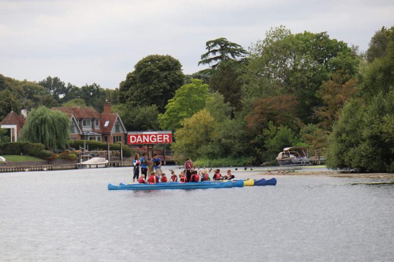 Twenty-ish kids on five boats moored up in the middle of the river.