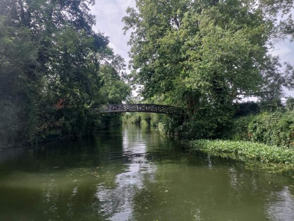 An arched wooden bridge spanning the narrow cut.