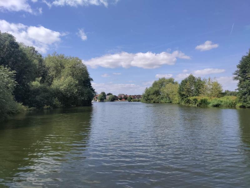 Trees on either side as the river curves to the left.