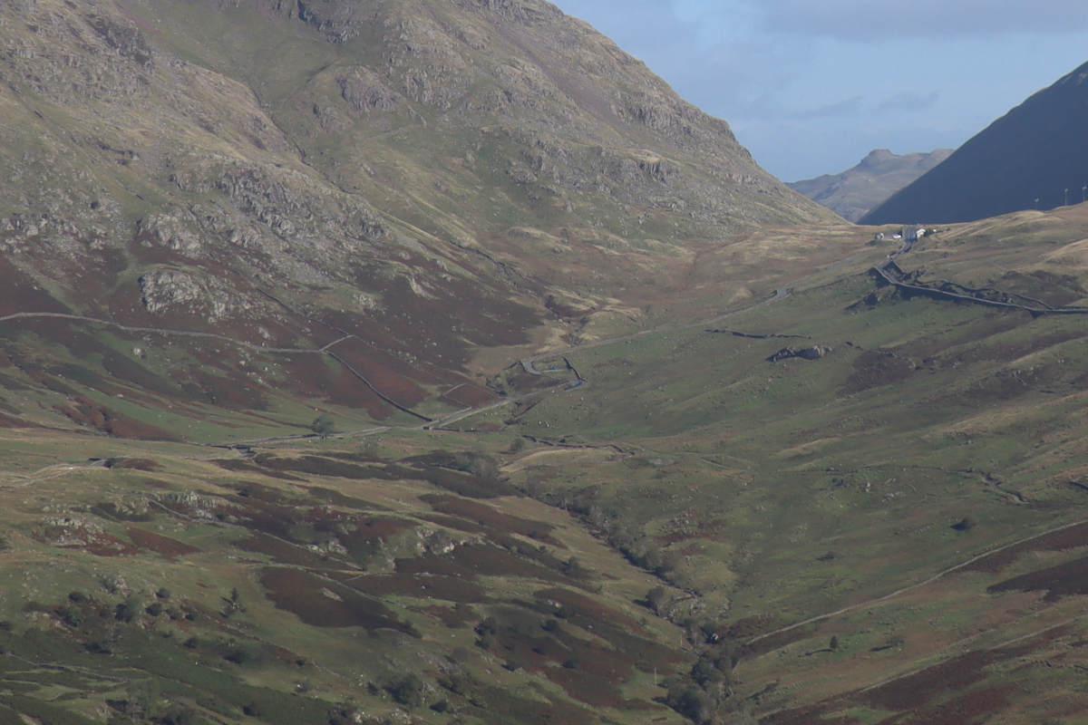 A steep and winding road in the distance.