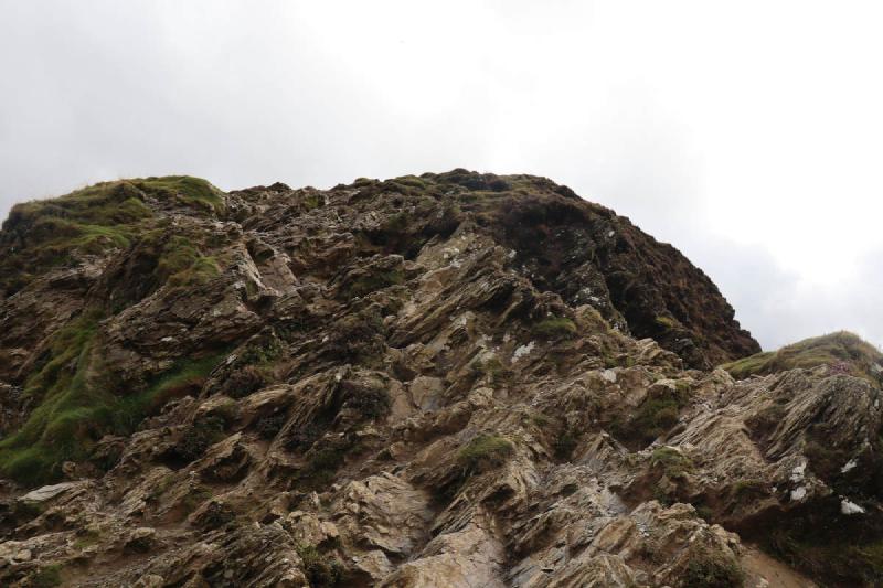 Looking up at some rough rocks and grass.
