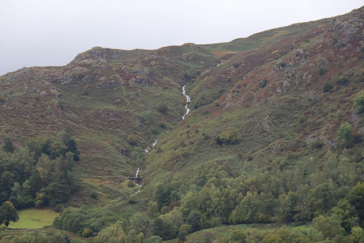 A distant stream falling down the hillside.